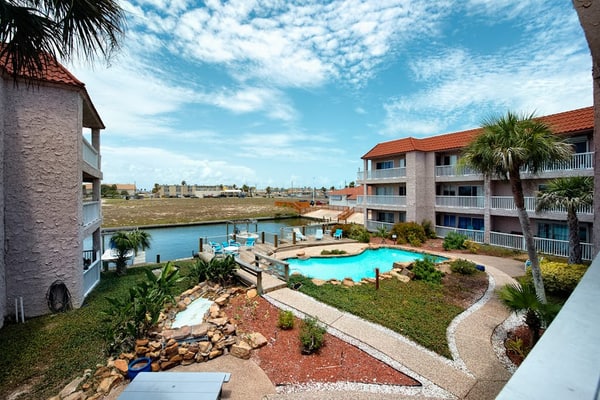 Coastal Bend condo with water views, dock, pool, sun deck, balcony, & W/D