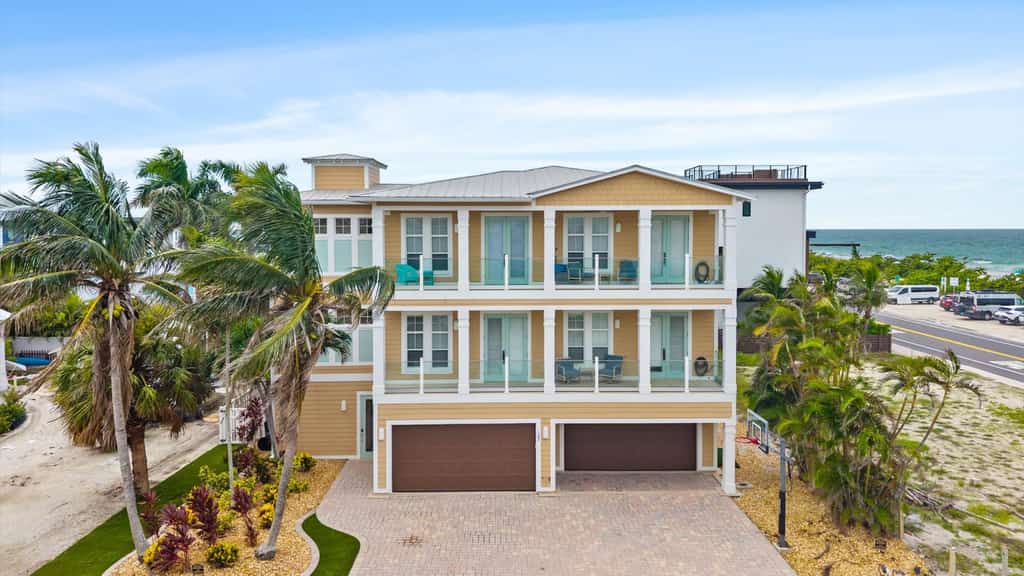 Welcome to The Pearl, a luxurious oceanfront Anna Maria Island vacation home where white-sand beaches and historic charm are just steps from your front door.

This 6-bedroom home is divided into two apartments with 3-bedrooms and 2.5 baths each, giving your large group plenty of space and privacy. Each floor offers unique and cozy coastal decor, an open-floor plan living room, secondary bedrooms sharing a Jack-and-Jill bath, and a primary suite with a king-sized bed, private oceanview balcony, and spa bath with garden tub. Unit B is on the 3rd floor, with both elevator and stair access.

The expansive backyard offers plenty of shaded space for dining and relaxing, along with an outdoor television, heated pool, and putting green.

Prepare and enjoy family meals in the stocked, ocean-view kitchen and informal dining room, or take advantage of shaded outdoor dining on the patio. Not in the mood to cook? Local favorites are just three blocks away at Historic Bridge Street, the epicenter of South AMI dining and nightlife.

When its time for the beach, you'll have everything you need, including towels, chairs, and umbrellas.

Key Features & Highlights:
Prime Location: This Anna Maria Island vacation home is located directly across the street from Cortez Beach, putting you just steps away from the ocean. Historic Bridge Street's dining, shopping and nightlife are just three blocks away.
Light & Airy Living: Open-concept living space designed for gathering with family or friends offers ocean views from the kitchen, dining nook, living room, and primary bedroom.
Beach Ready: Beach gear included so you can sink your toes into the sand from day one!

Book now and see why this expansive oceanview vacation home is truly The Pearl of Anna Maria Island.