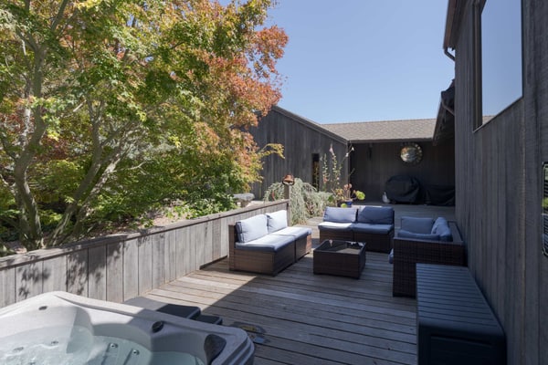 Expansive ocean views from the living room, dining table, and primary bedroom, and a chef's kitchen guests call top notch, with a gas range, air fryer, stocked spice rack, and a monster dining table for meals and puzzles. Floor-to-ceiling stone wood-burning fireplace, private hot tub on the enclosed courtyard, fenced yard for kids and the dog, EV charger. Sleeps 8 in 3 queens plus a sleeper sofa. Trail below the house; Shell Beach is a 15-to-20-minute walk. One pup per stay.