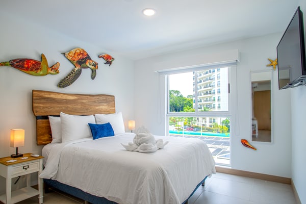 Welcome to your stylish coastal escape! This modern condo, just 3 minutes from vibrant Jaco, blends contemporary comfort with beach-inspired charm. Featuring sleek furnishings and marine-themed decor, the open-concept living area boasts expansive windows that frame stunning resort views.
The fully equipped kitchen includes high-end appliances and chic countertops, ideal for preparing meals. The adjacent dining and living spaces are perfect for relaxing or entertaining. Each luxurious bedroom offers plush bedding and serene views of the resort, ensuring a restful stay.
Step onto your private balcony to enjoy morning coffee or evening drinks with breathtaking sunsets. The complex includes exceptional amenities: three sparkling pools, a BBQ area, a state-of-the-art gym, and a versatile meeting room.
With Jaco’s vibrant nightlife, trendy shops, and dining options just a short drive away, this condo offers the ideal mix of relaxation and convenience. Book now to experience modern elegance, spectacular views, and unmatched comfort in your perfect beachfront retreat.