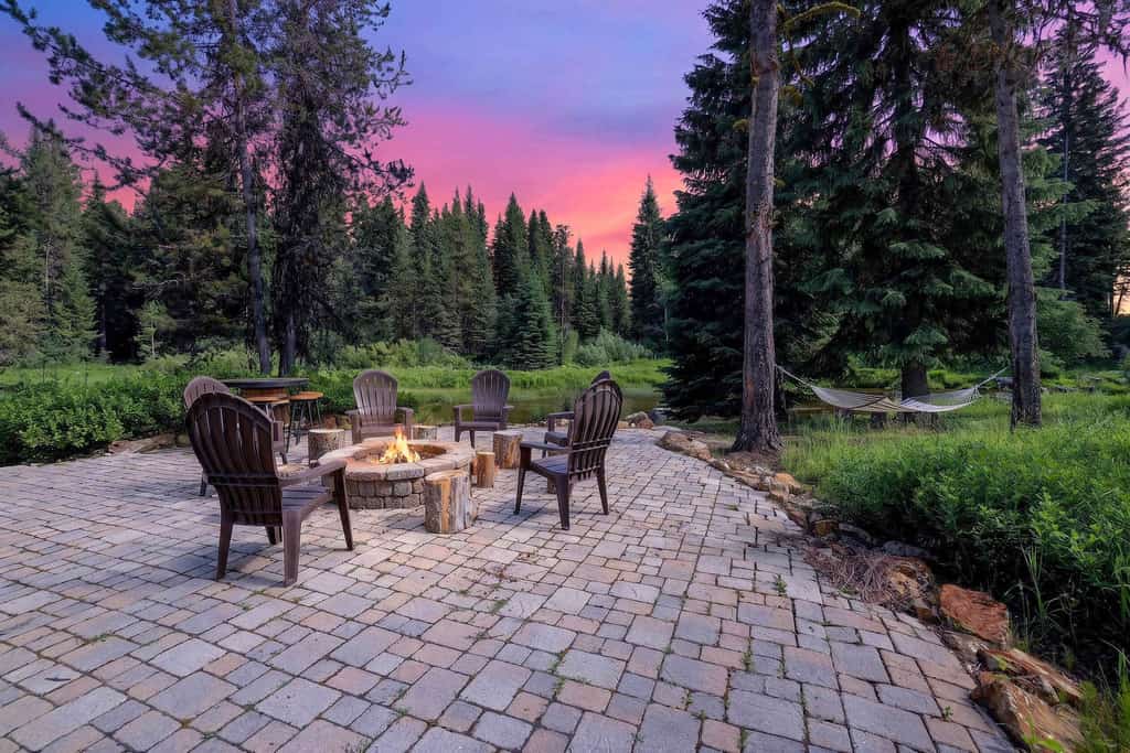 A spacious, pet-friendly five-bedroom mountain retreat along Lake Fork Creek, just 5 miles from downtown McCall. Surrounded by pines, this cabin sleeps up to 12 and features an indoor hot tub, two main-level primary suites, a game loft with foosball, and a large deck overlooking the river. Enjoy a creekside fire pit, outdoor seating, and plenty of space for gathering, with convenient access to year-round recreation.