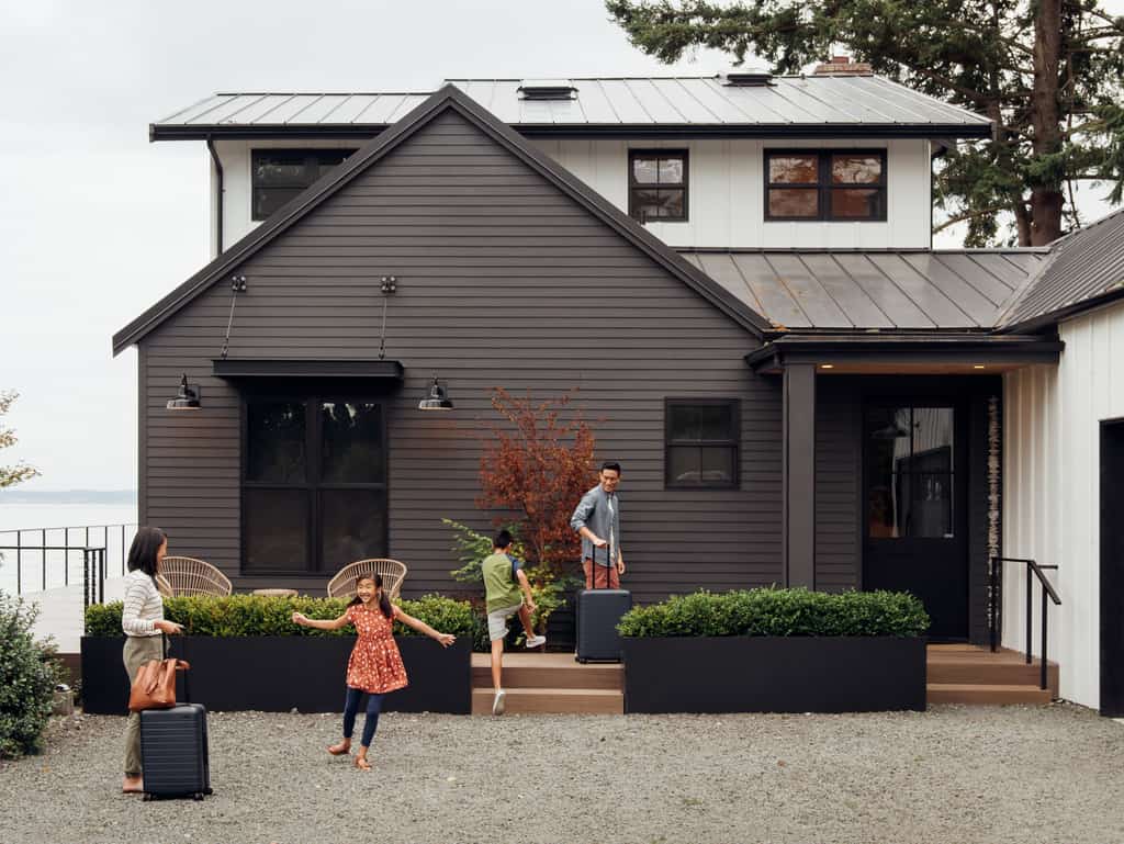 a family arriving at their vacation home by the ocean