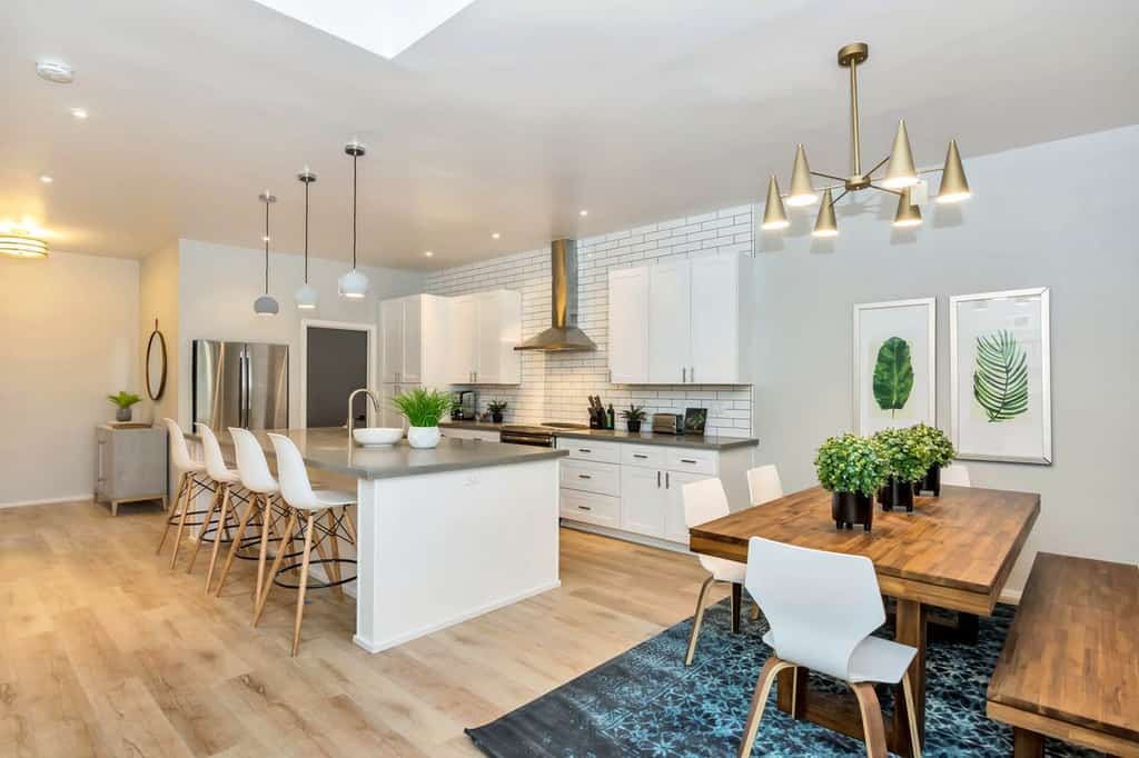 modern kitchen with white cabinets and backsplash and faux greenery accents