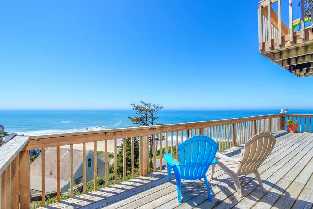 Two beach chairs on a deck overlooking the Oregon Coast.