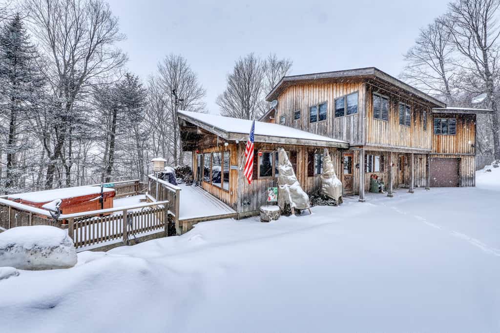 A snow covered lodge with a hot tub in Killington, VT.