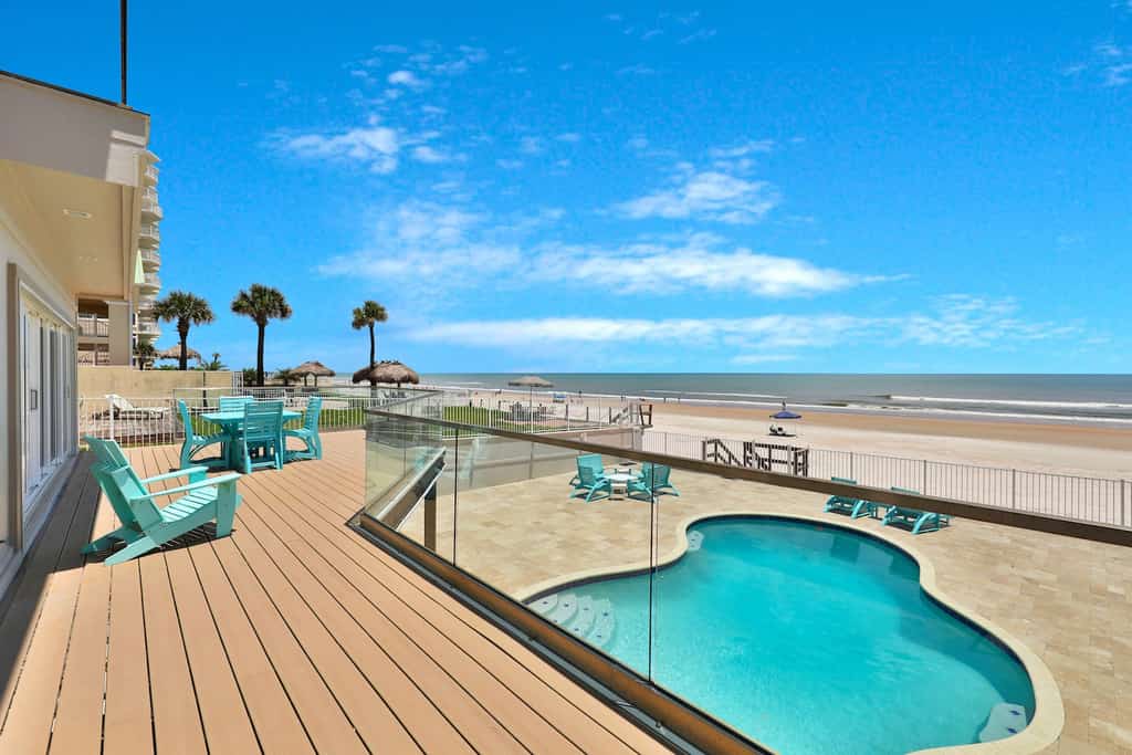 View from a deck overlooking the ocean and a pool at a rental in Daytona Beach.