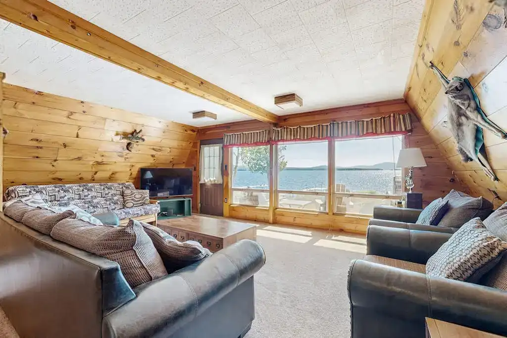 cabin living room with large windows and waterfront views