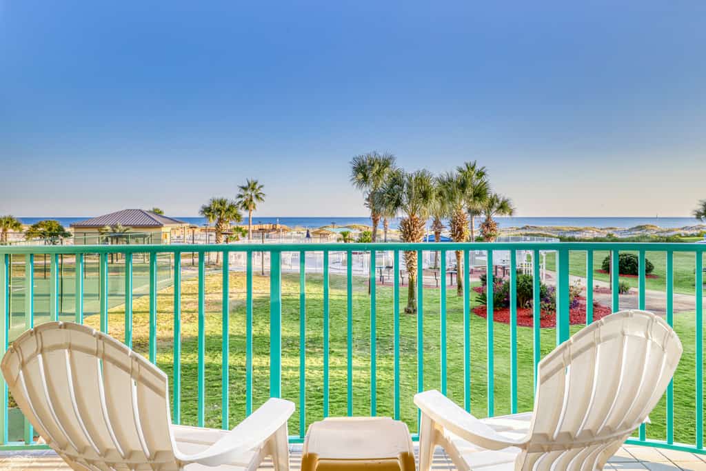 Two chairs on a balcony facing the beach on a sunny day in Gulf Shores, AL