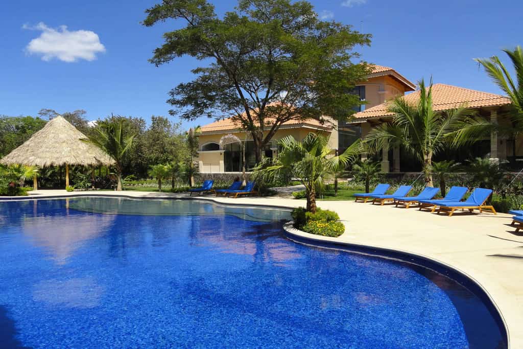 Pool surrounded by palm trees and cabana at a community association