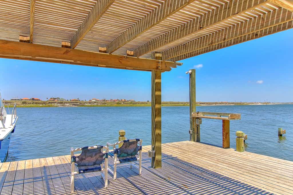 Two folding chairs sit on dock of vacation rental in Corpus Christi
