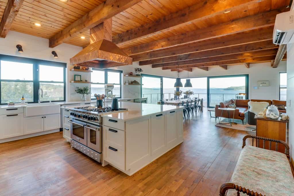 open kitchen layout with copper hood and wooden beams  and crisp white cabinets and countertops