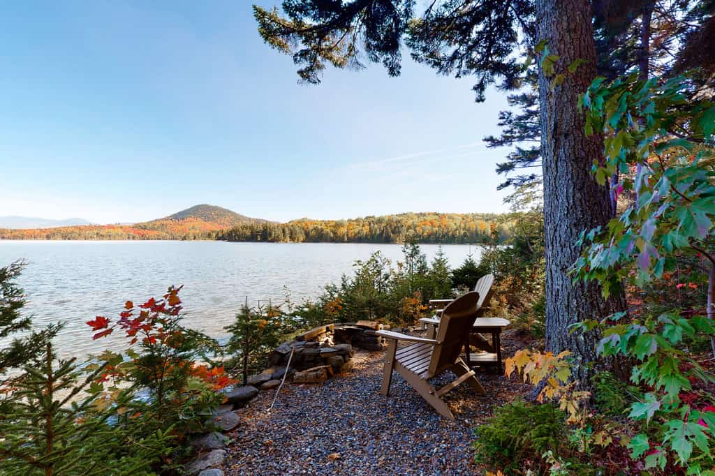 Adirondack chairs perched at the water's edge in Moosehead Lake