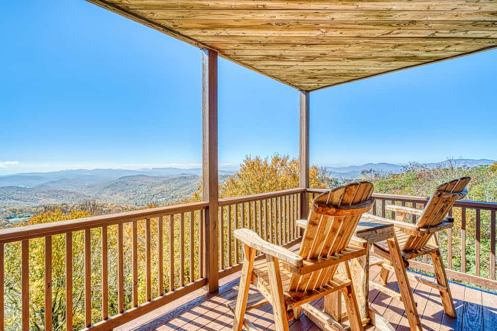 two chairs of cabin overlook the gorgeous blue ridge mountains on a beautiful sunny day