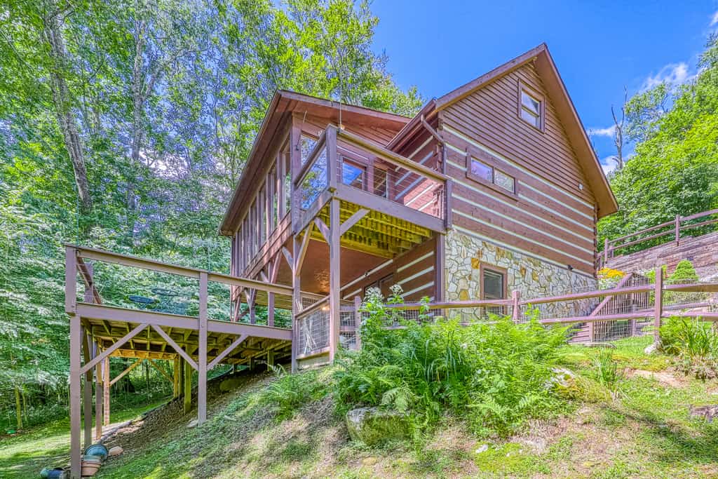 Beautiful Sugar Mountain, NC cabin rental on a slope surrounded by a green landscape.