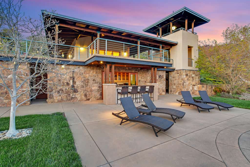 two story vacation rental with outdoor bar and lounge chairs