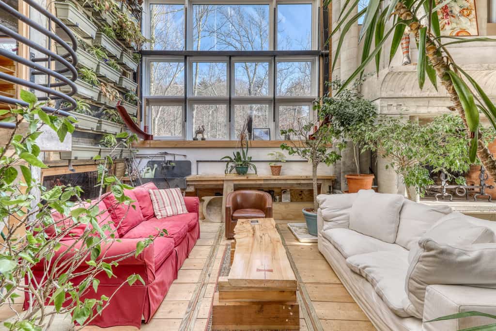 industrial-style interior architecture with a two-story living wall of plants and a forest of potted trees