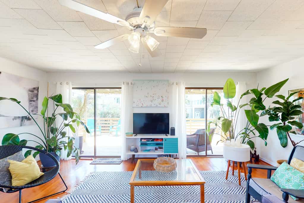 plant stands dot the living area of this beachside rental in Folly Beach