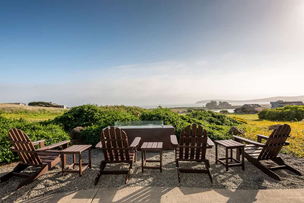 Chairs and tables overlooking a beautiful coastal setting a rental in Bodega Bay, CA.