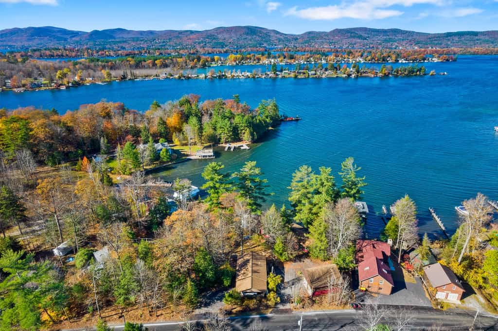 Drone shot of a lake in the Adirondacks alongside vacation rentals.