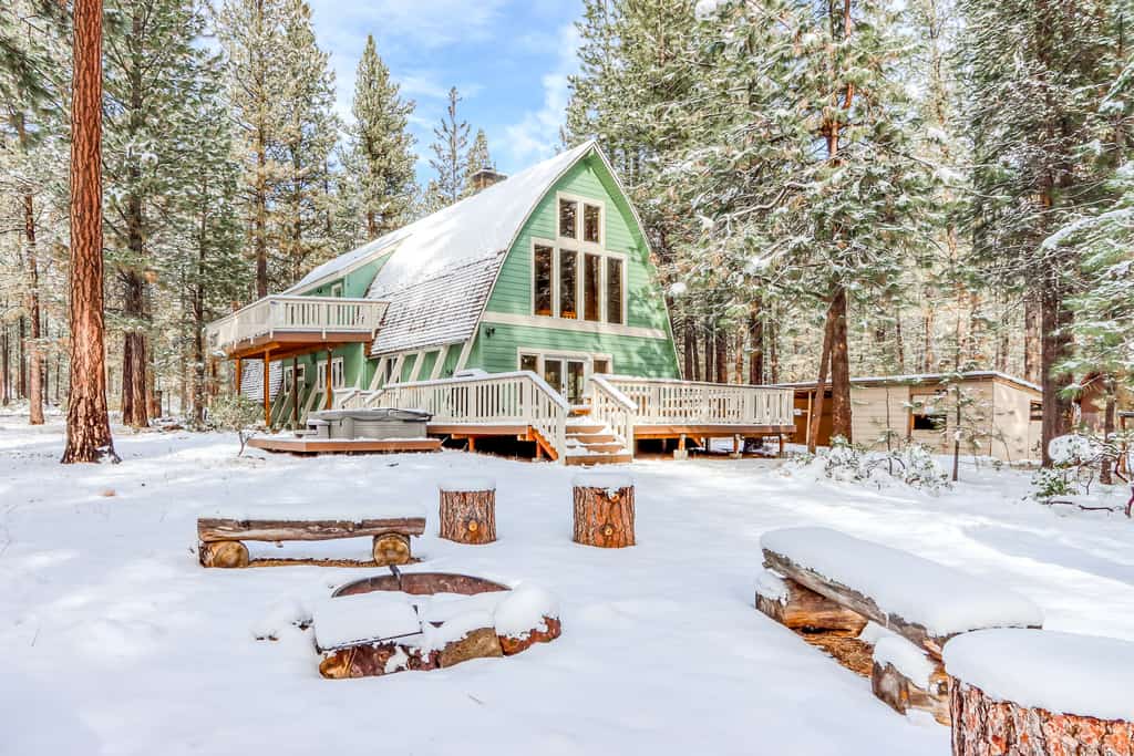 green chalet-style home covered in snow in winter in sunriver