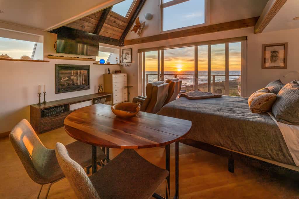 A studio with a bedroom and table at a vacation rental in Fort Bragg as pictured during sunset.