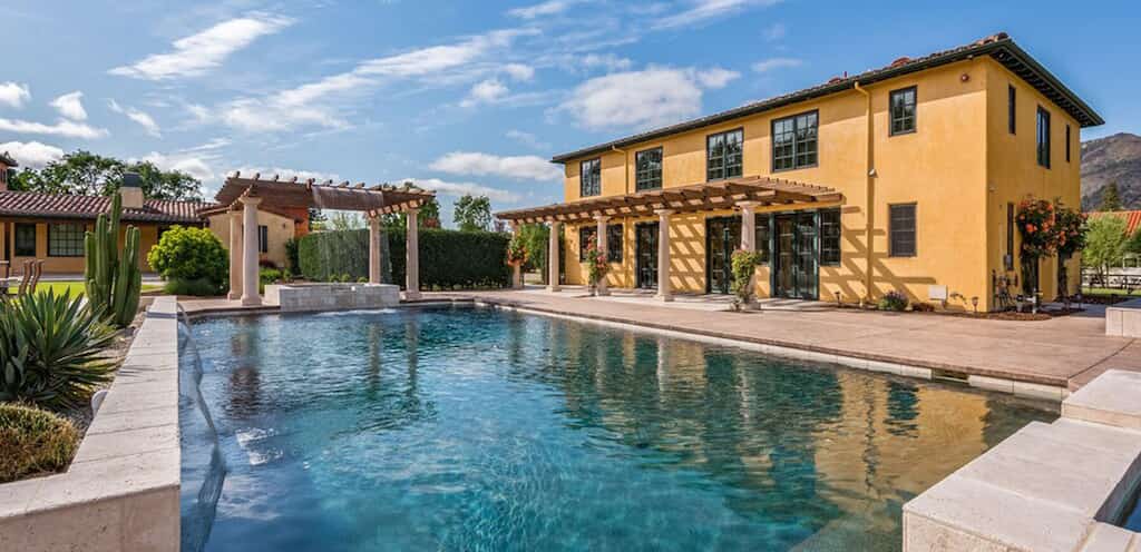 Yellow stucco vacation home in California with outdoor pool surrounded by cacti