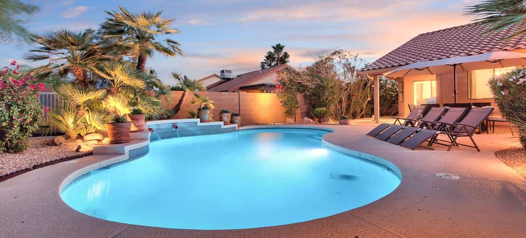 outdoor pool surrounded by lounge chairs and palm trees in arizona