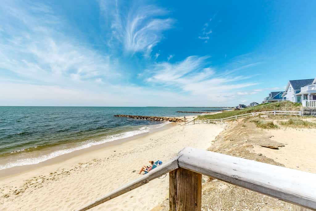Sunbathers sit on the beach in Dennis Port, MA
