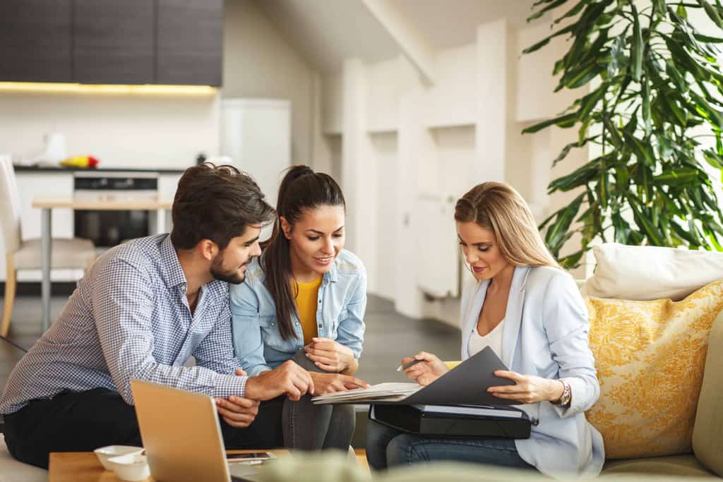 vacation home buyers sitting with their real estate agent