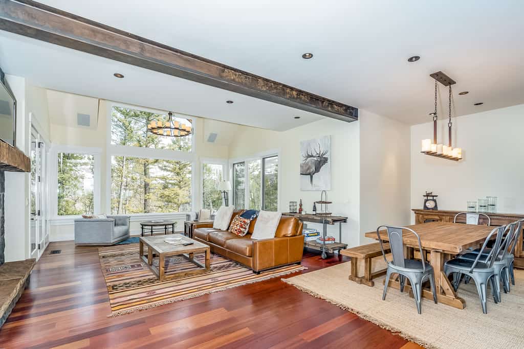 Colorado vacation home with wood floors, a leather couch, exposed beams and additional modern touches