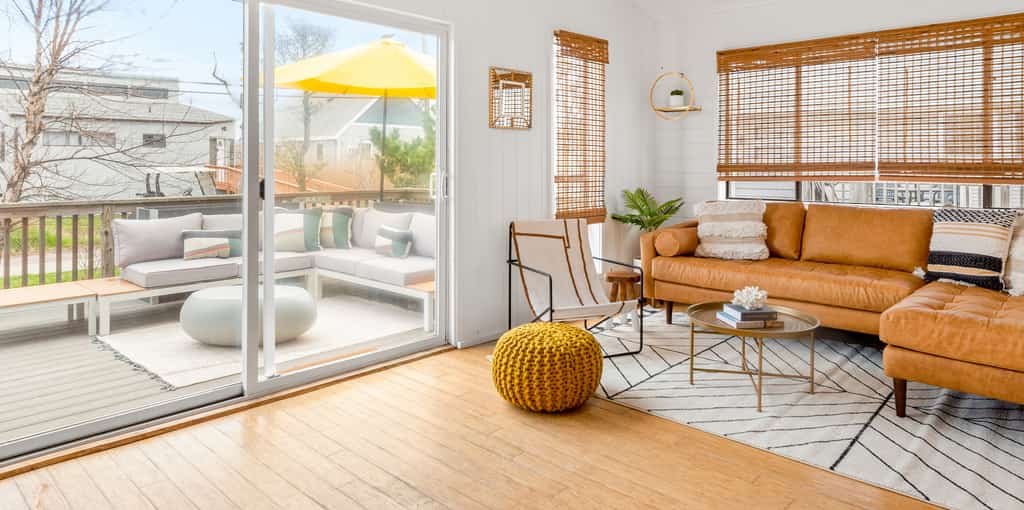 Tan couch and bamboo curtains inside Fire Island, NY vacation home