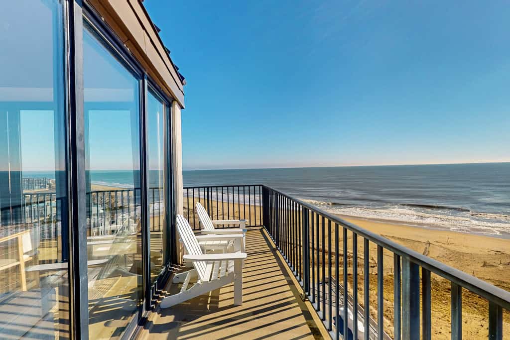 two chairs sit on balcony overlooking the ocean in bethany beach