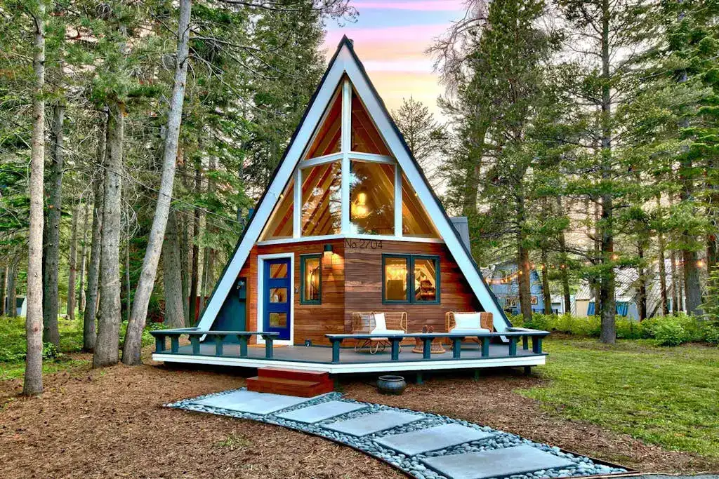 front exterior of an A-frame cabin in the woods