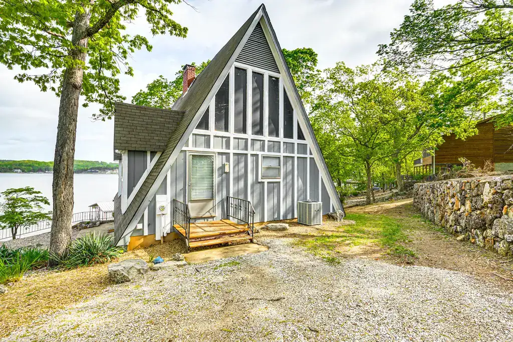 front of A-frame cabin by a lake