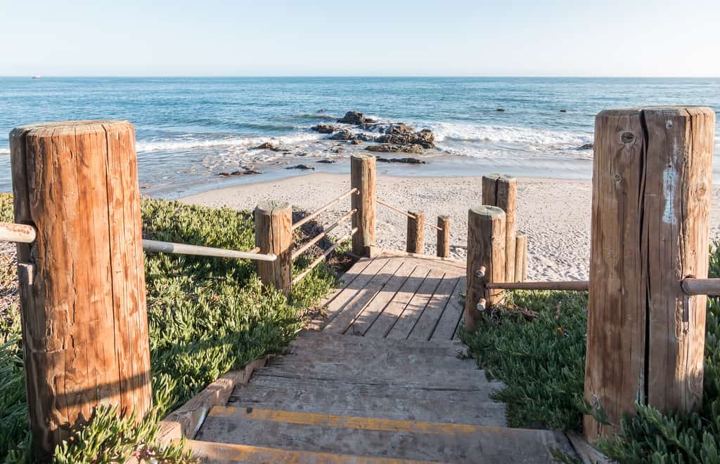 Wooden path leads down to beach in California