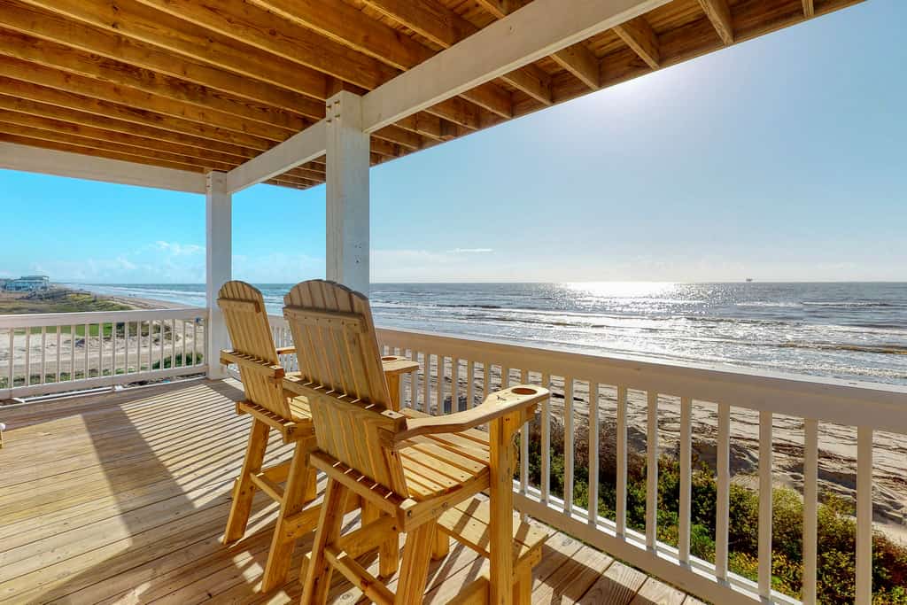 two chairs sit under a covered deck facing the Gulf in Crystal Beach, TX