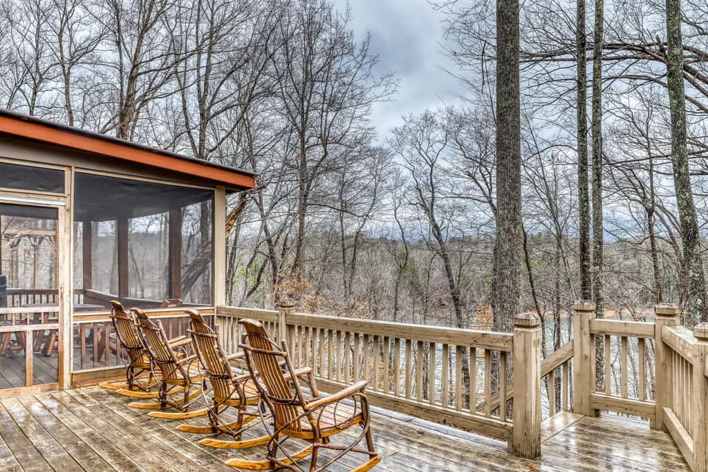 four rocking chairs on a deck face the lake in blue ridge, ga