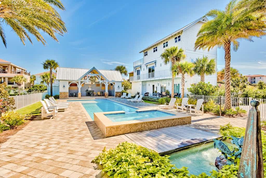 The back deck of a vacation rental in Miramar Beach, Florida with a pool and a covered area.