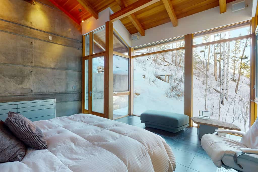 A cozy vacation home room with modern furniture and floor-to-ceiling windows in Gore Creek, CO.