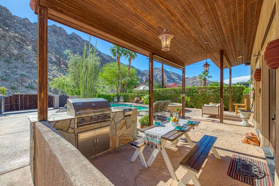 covered porch with gas grill and seating with private pool and mountains in the background