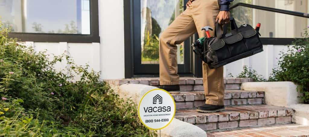 Man holding a tool kit walking up to a home.