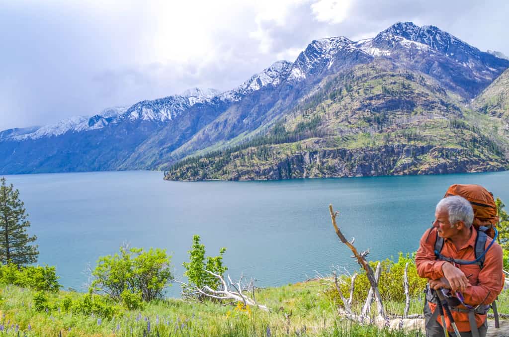 Man backpacking on a trail near Lake Chelan near a beautiful mountain range