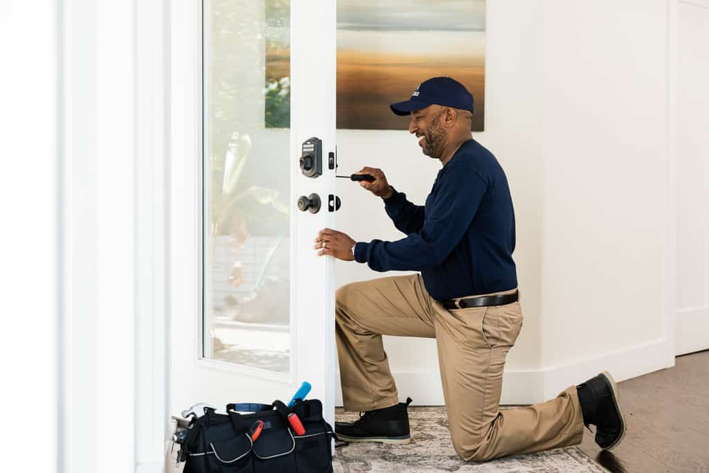 Man installing a smart lock to a vacation rental door