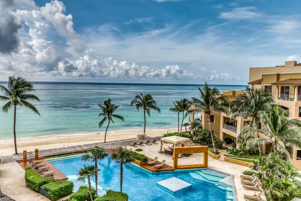 The pool area at a resort in Mexico near the ocean.