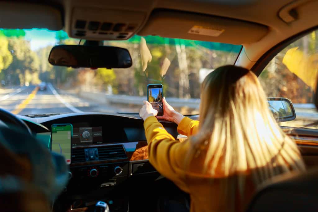 Passenger in a car taking a photo