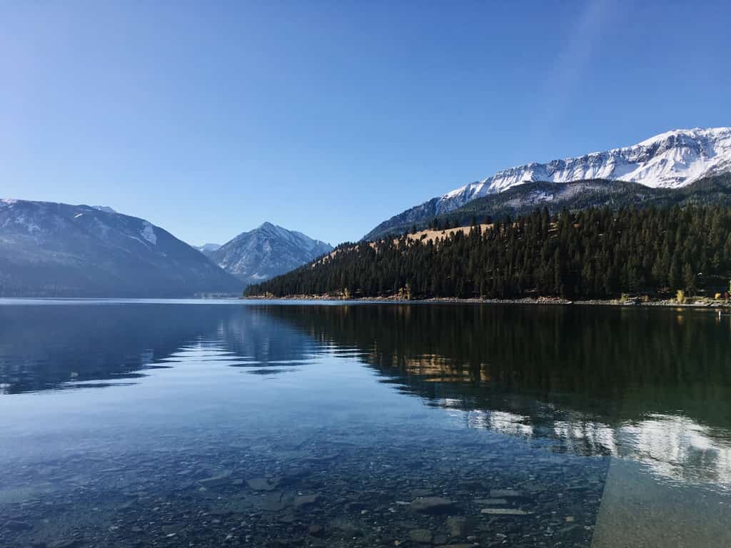 Clear water at Wallowa Lake with mountains in the background.