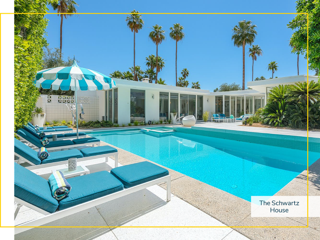 Vacation home with an outdoor pool filled with clear blue water and pool lounge chairs on a sunny day.