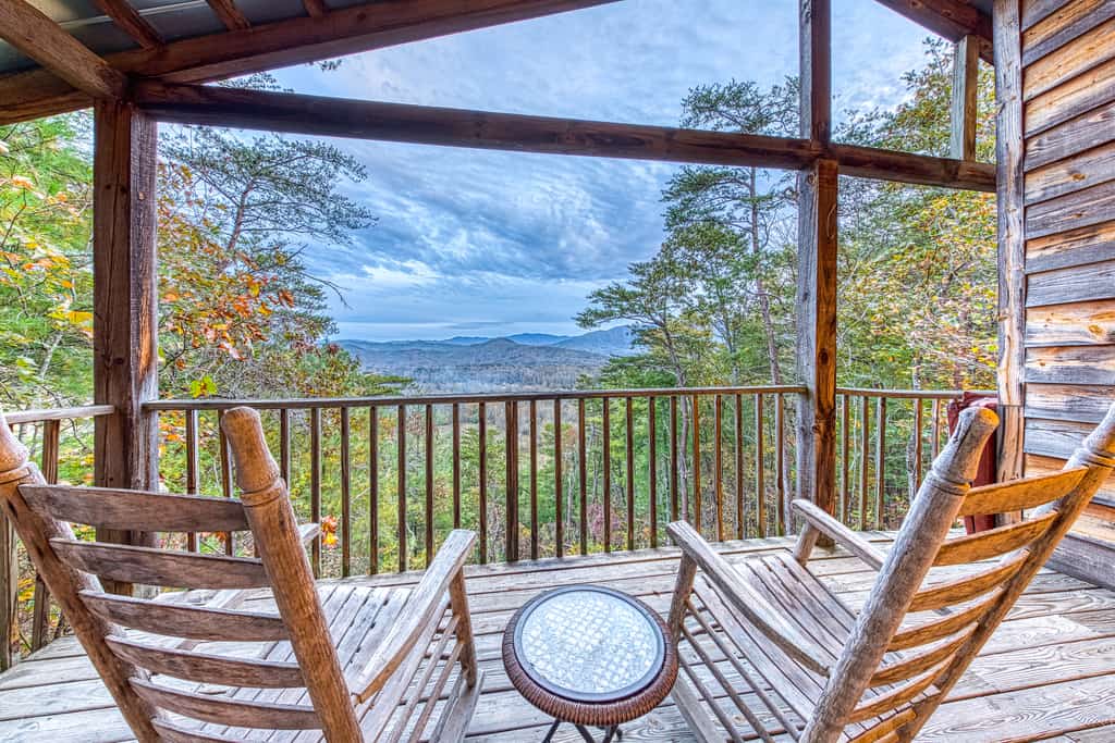 two rocking chairs sit on deck of smoky mountains cabin