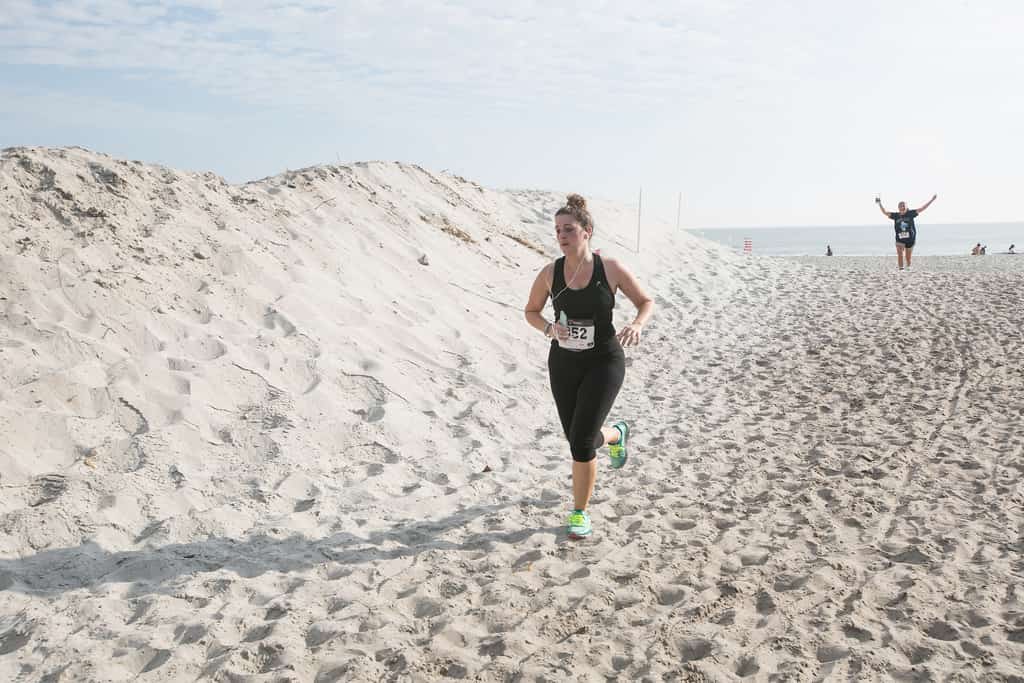 a woman running on the beach in a florida keys race
