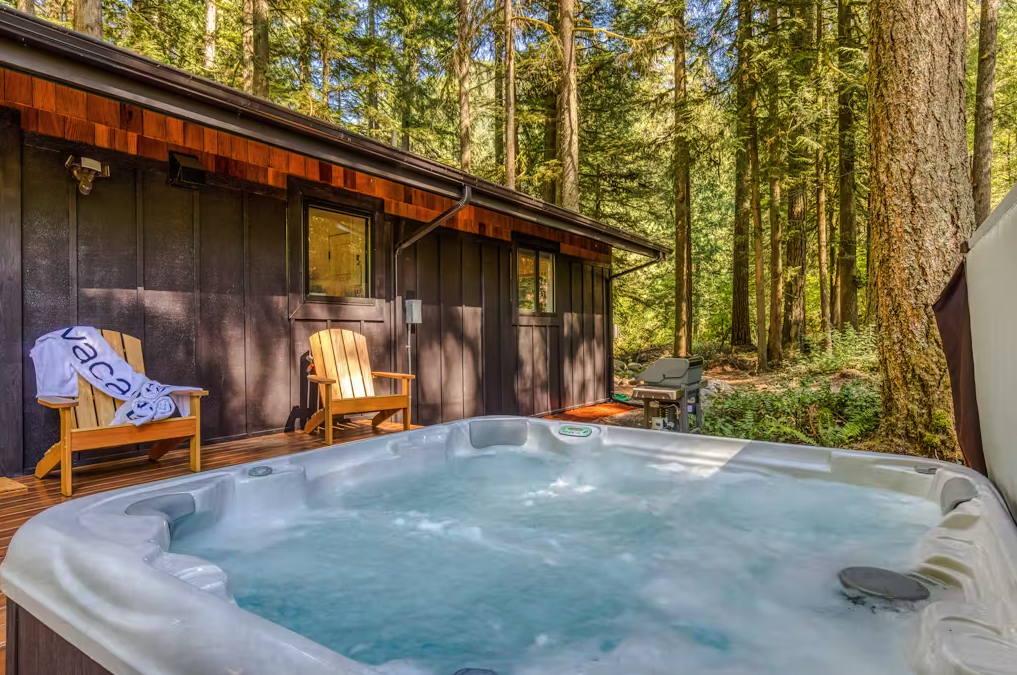 a hot tub with a beach towel and adirondack chairs nearby